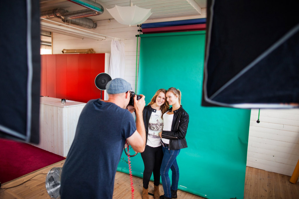 Rear view of photographer photographing fashion models in studio ...